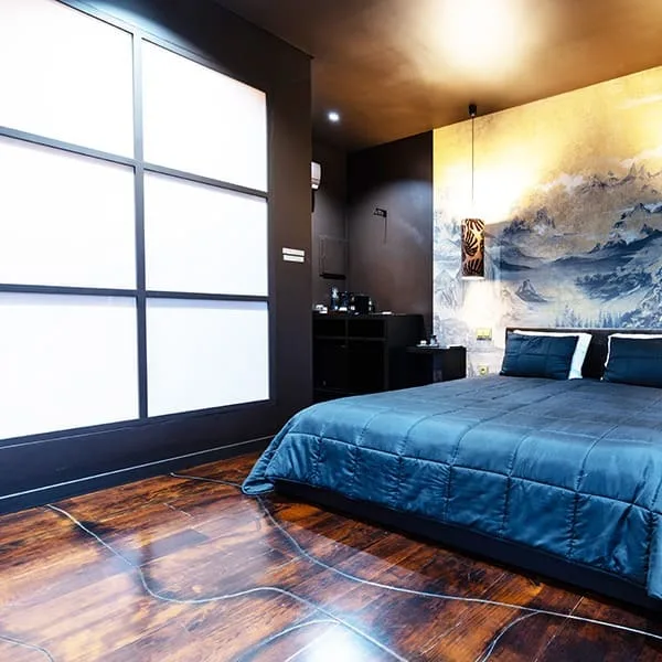Quarto Yugen com cama azul e luz natural